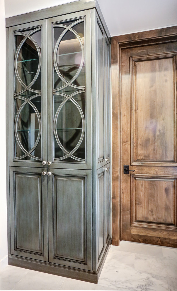 Photo of a small country built-in wardrobe in Phoenix with glass-front cabinets, blue cabinets, marble floors and white floor.