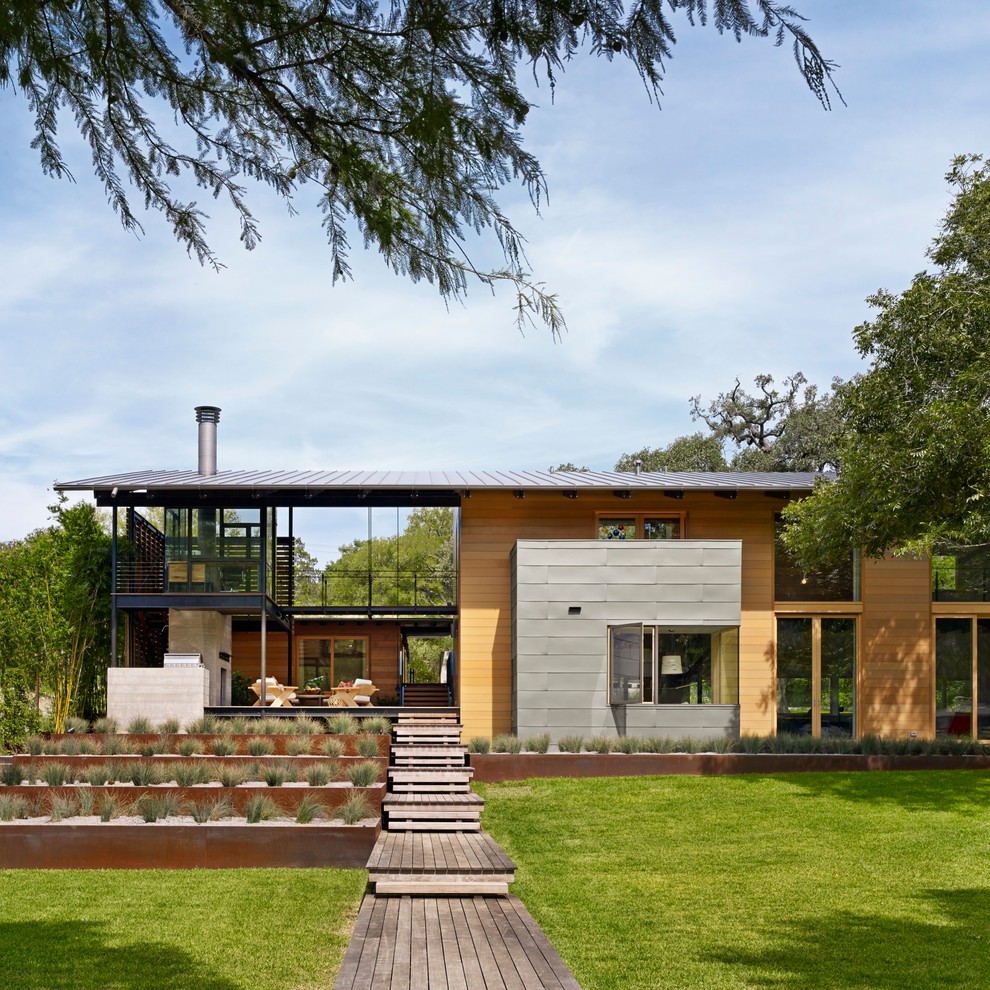 Design ideas for a contemporary two-storey exterior in Austin with wood siding and a shed roof.