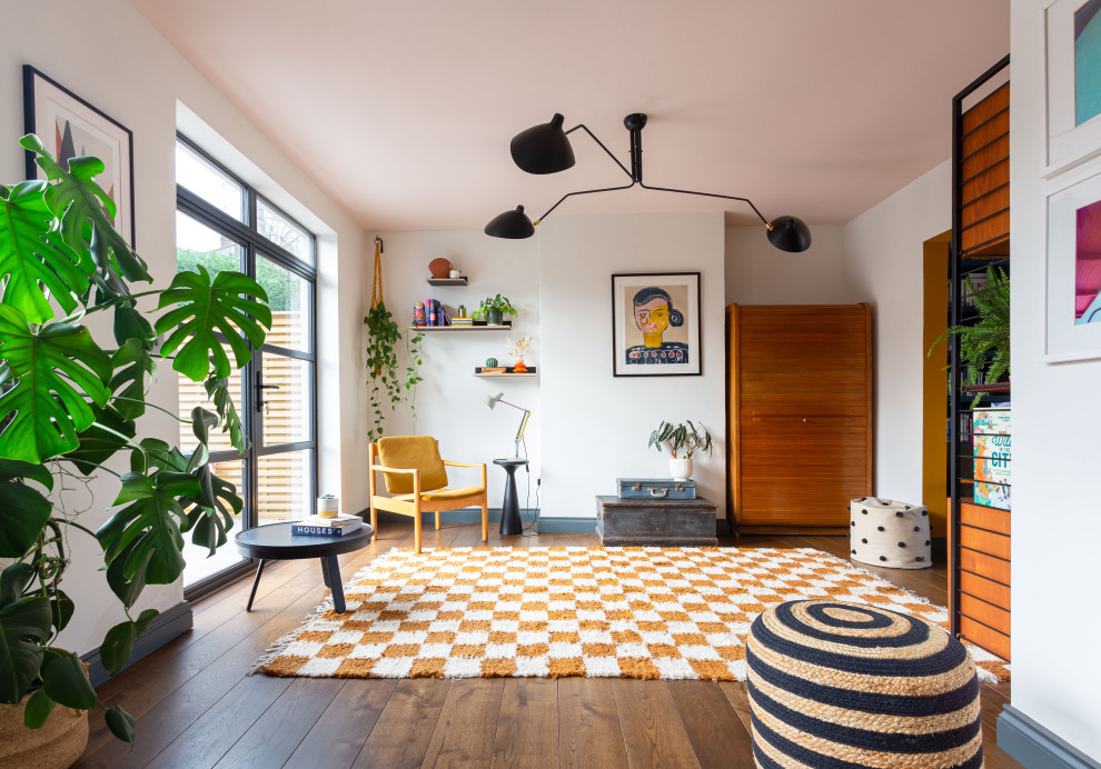 Foto de salón abierto bohemio de tamaño medio con paredes blancas y suelo de madera en tonos medios