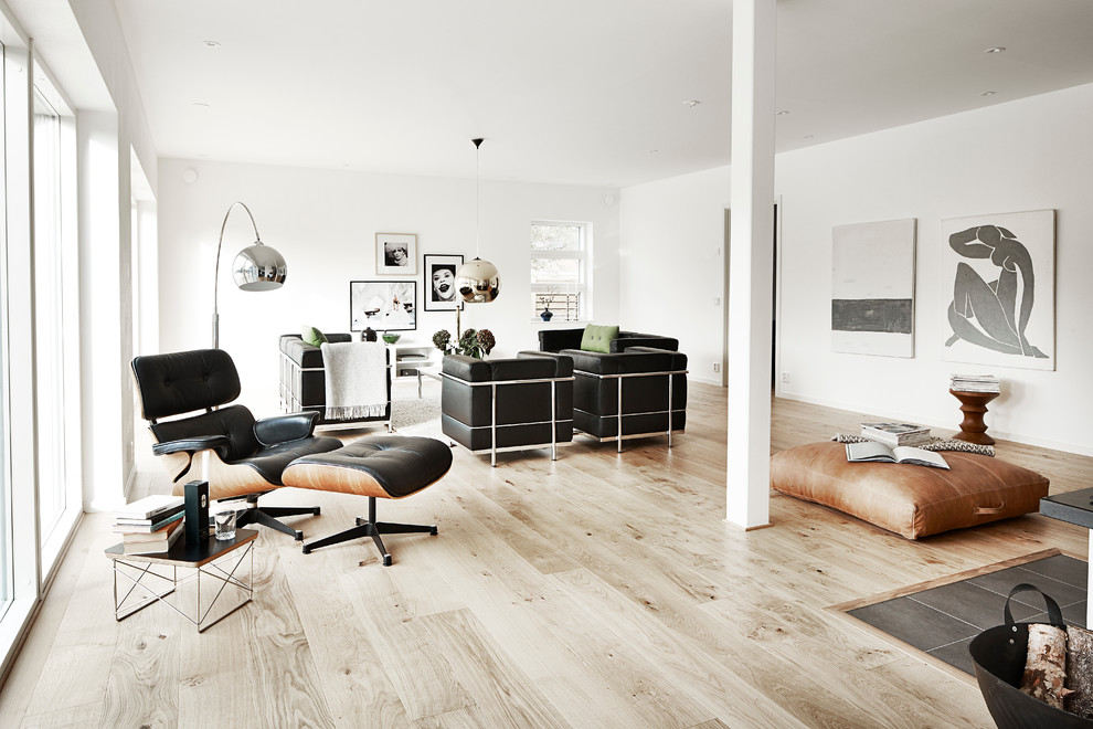 Photo of a large scandinavian formal open concept living room in Malmo with white walls, light hardwood floors, no tv and no fireplace.