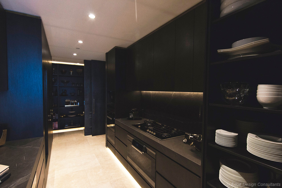 Large modern galley kitchen pantry in Sydney with an undermount sink, flat-panel cabinets, dark wood cabinets, tile benchtops, grey splashback, porcelain splashback, black appliances, porcelain floors, no island, beige floor and grey benchtop.