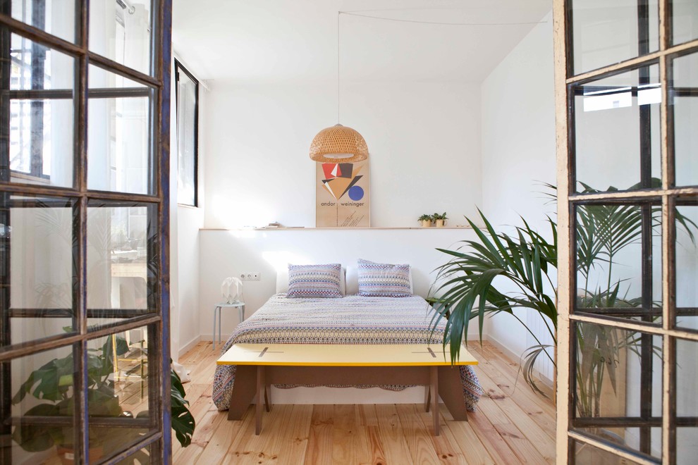Inspiration for a large scandinavian master bedroom in Barcelona with white walls and light hardwood floors.