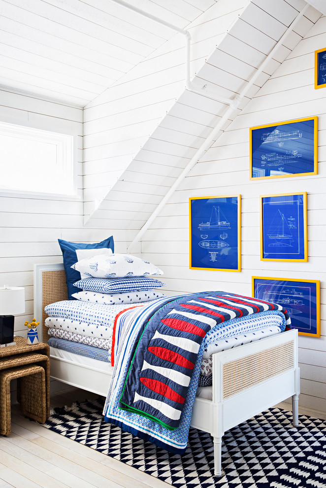 Photo of a mid-sized beach style kids' bedroom for boys in New York with white walls and light hardwood floors.