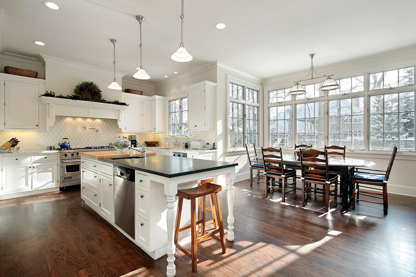 Traditional kitchen in Chicago with an undermount sink, white cabinets, white splashback, stainless steel appliances, dark hardwood floors and with island.