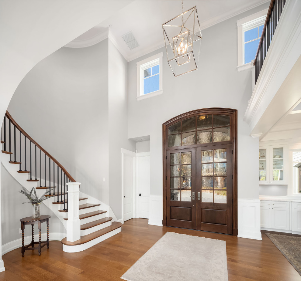 This is an example of a large beach style foyer in Seattle with grey walls, medium hardwood floors, a double front door, a medium wood front door and brown floor.
