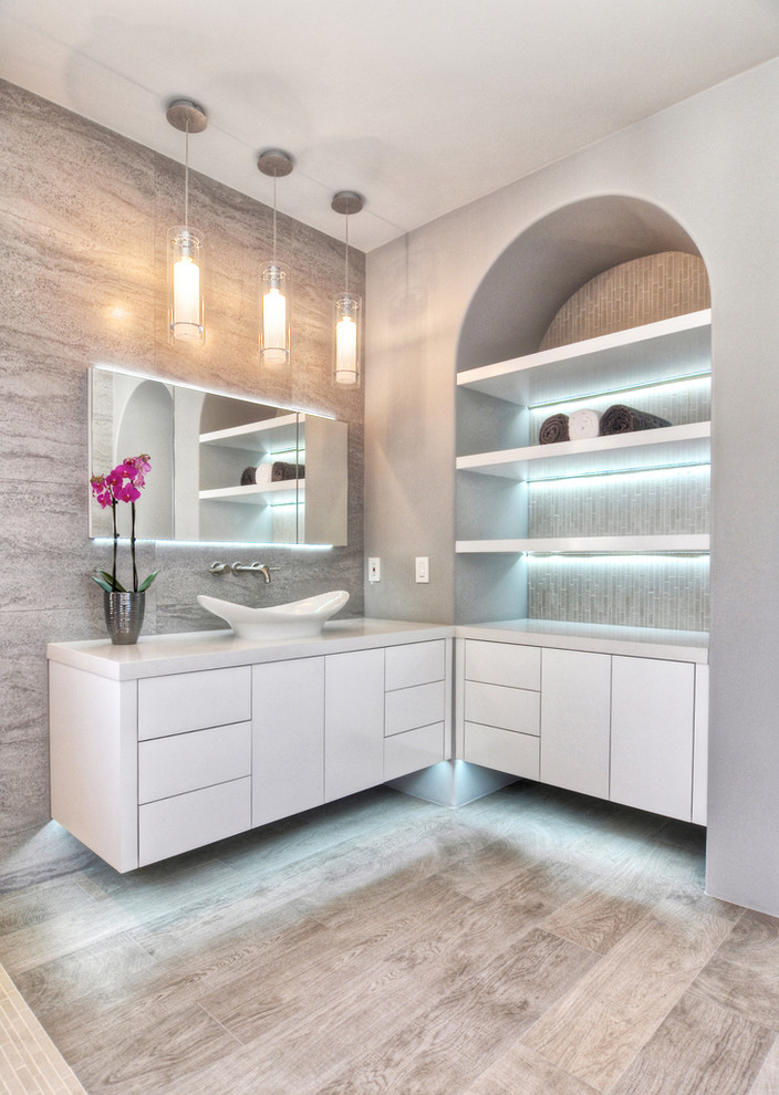 Huge trendy master gray tile and ceramic tile ceramic tile freestanding bathtub photo in Orange County with flat-panel cabinets, white cabinets, a one-piece toilet, gray walls, a vessel sink and quartz countertops