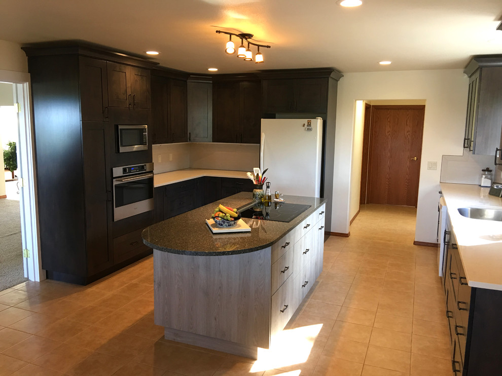 Photo of a mid-sized transitional l-shaped eat-in kitchen in Seattle with a single-bowl sink, shaker cabinets, dark wood cabinets, quartzite benchtops, white splashback, porcelain splashback, stainless steel appliances, porcelain floors and with island.