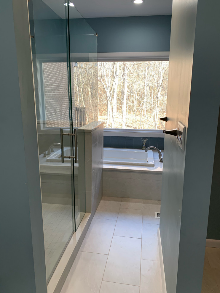 Design ideas for a medium sized modern ensuite bathroom in Cincinnati with flat-panel cabinets, dark wood cabinets, a built-in bath, a double shower, a two-piece toilet, porcelain tiles, blue walls, porcelain flooring, a submerged sink, engineered stone worktops, white floors, a hinged door, white worktops, a shower bench, double sinks, a built in vanity unit and white tiles.