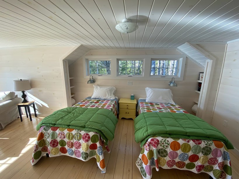 Réalisation d'une chambre parentale nordique en bois de taille moyenne avec un mur blanc, parquet clair et un plafond en bois.