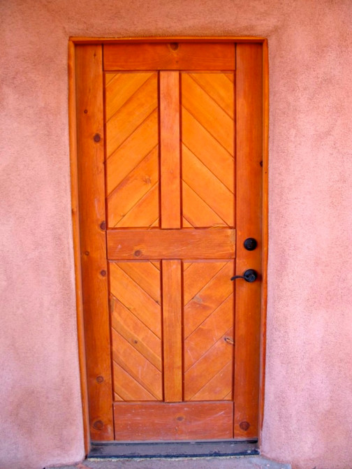 Photo of a mid-sized transitional front door in Albuquerque with beige walls, concrete floors, a single front door and a medium wood front door.