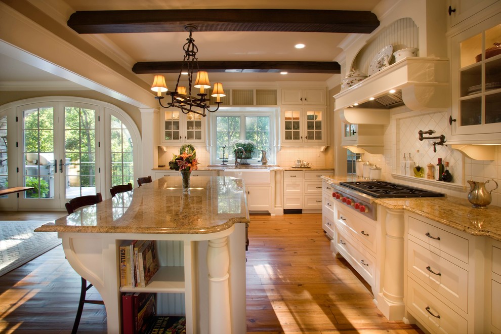 Inspiration for a traditional kitchen in Minneapolis with glass-front cabinets, a farmhouse sink and granite benchtops.