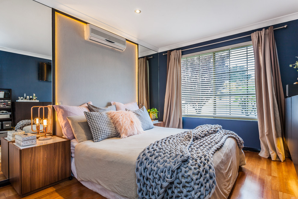Inspiration for a contemporary master bedroom in Perth with blue walls, medium hardwood floors and brown floor.