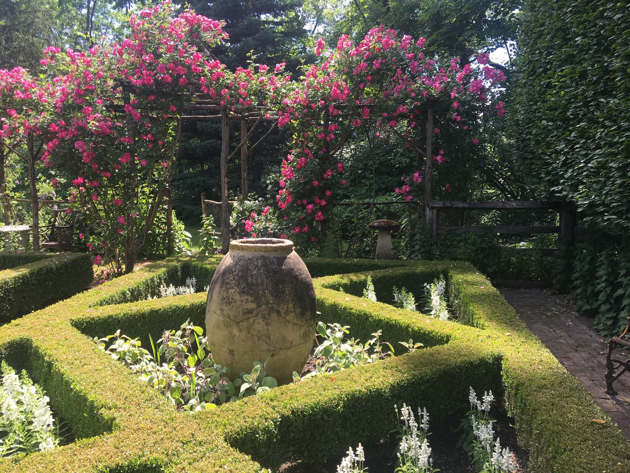 Formal Boxwood Garden with Italian urn. The beds are filled with different shades of white perennials. In the foreground is white Salvia and Sage around the Urn. Private Garden. Photo by Peter H. Atki