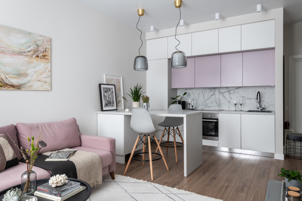 This is an example of a small scandinavian galley open plan kitchen in Moscow with flat-panel cabinets, white cabinets, solid surface benchtops, white splashback, ceramic splashback, stainless steel appliances, with island, brown floor and grey benchtop.