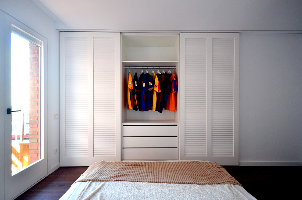 Design ideas for a mid-sized modern storage and wardrobe in Barcelona with dark hardwood floors.