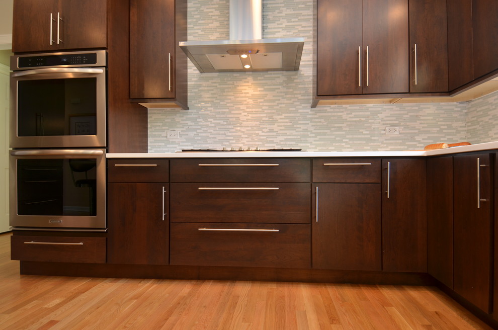 Inspiration for a mid-sized transitional l-shaped light wood floor eat-in kitchen remodel in Chicago with an undermount sink, flat-panel cabinets, dark wood cabinets, quartzite countertops, multicolored backsplash, matchstick tile backsplash, stainless steel appliances and an island