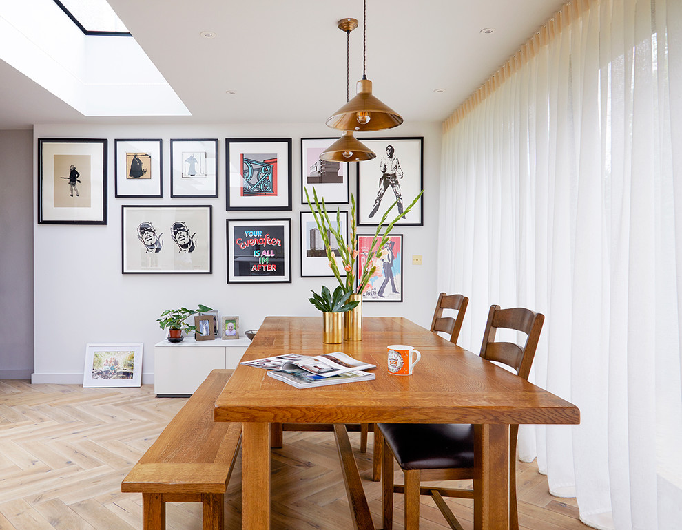 Photo of a large transitional dining room in London with white walls, light hardwood floors and beige floor.