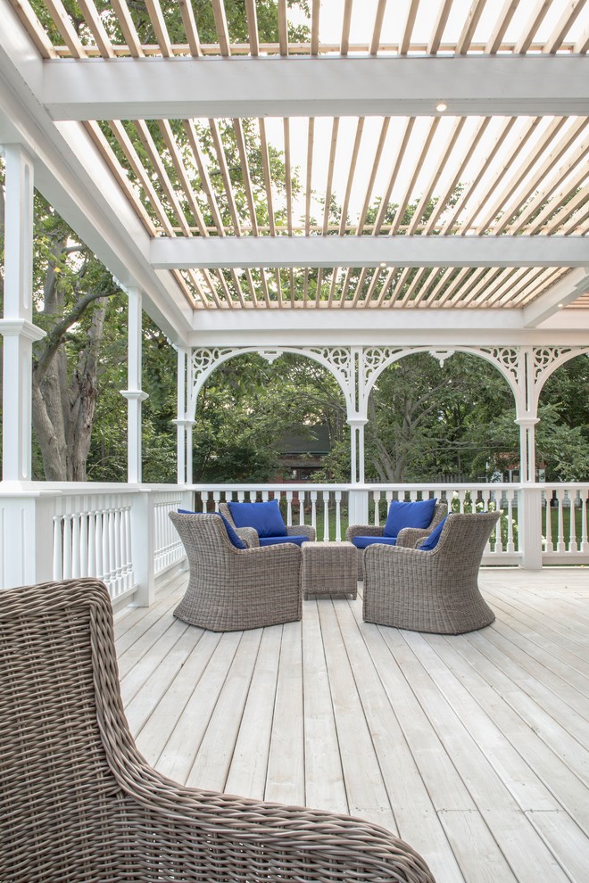 Large scandinavian backyard patio in Toronto with decking and a pergola.