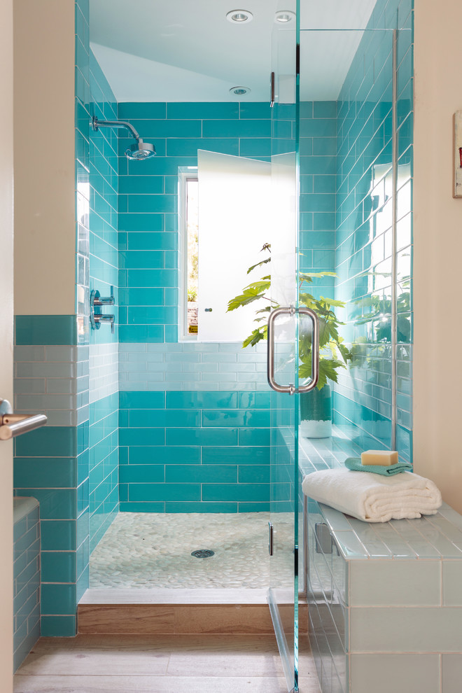 Beach style bathroom in Boston with blue tile, an alcove shower, flat-panel cabinets, dark wood cabinets, an alcove tub, glass tile, white walls, light hardwood floors, wood benchtops and a hinged shower door.