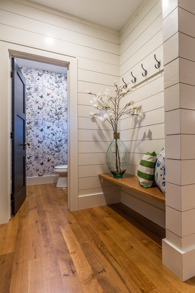 Inspiration for a large transitional medium tone wood floor mudroom remodel in Cedar Rapids with white walls