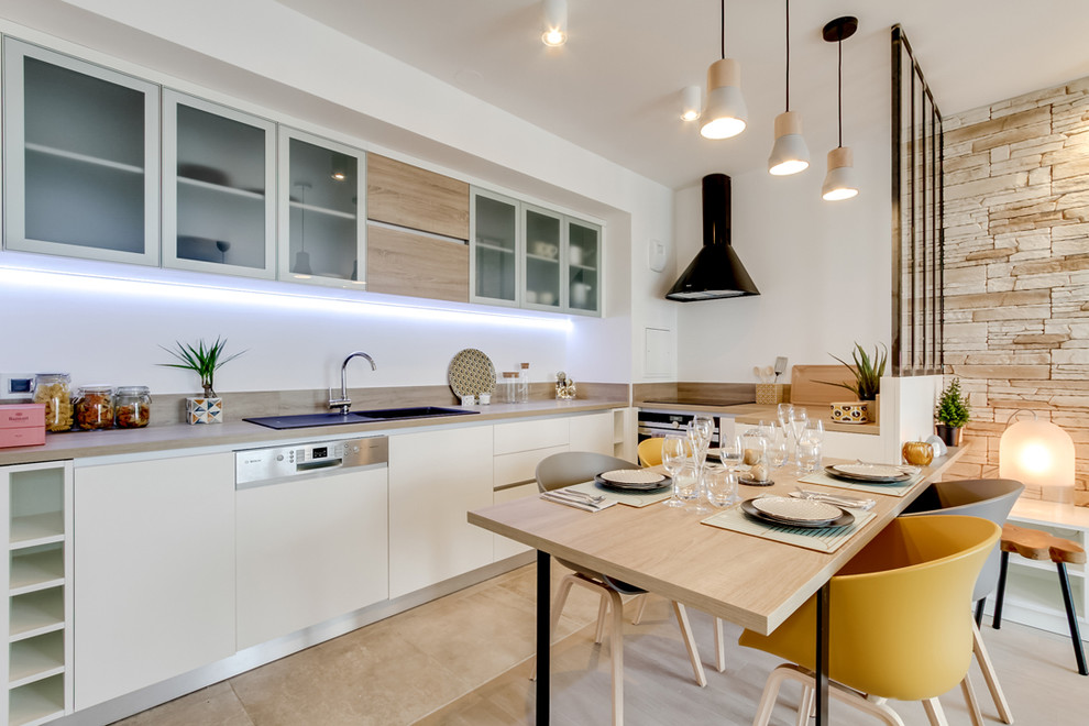 Inspiration for a mid-sized scandinavian u-shaped eat-in kitchen in Paris with an integrated sink, flat-panel cabinets, light wood cabinets, wood benchtops, white splashback, panelled appliances, travertine floors, no island and beige floor.