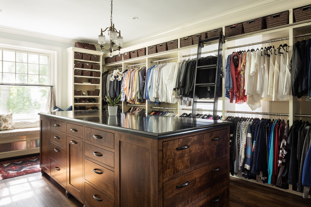 Inspiration for a traditional gender-neutral walk-in wardrobe in New York with open cabinets, dark hardwood floors and brown floor.