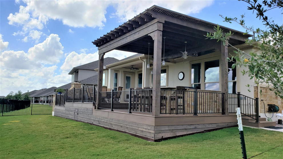 Large eclectic backyard metal railing outdoor kitchen deck photo in Austin with a pergola