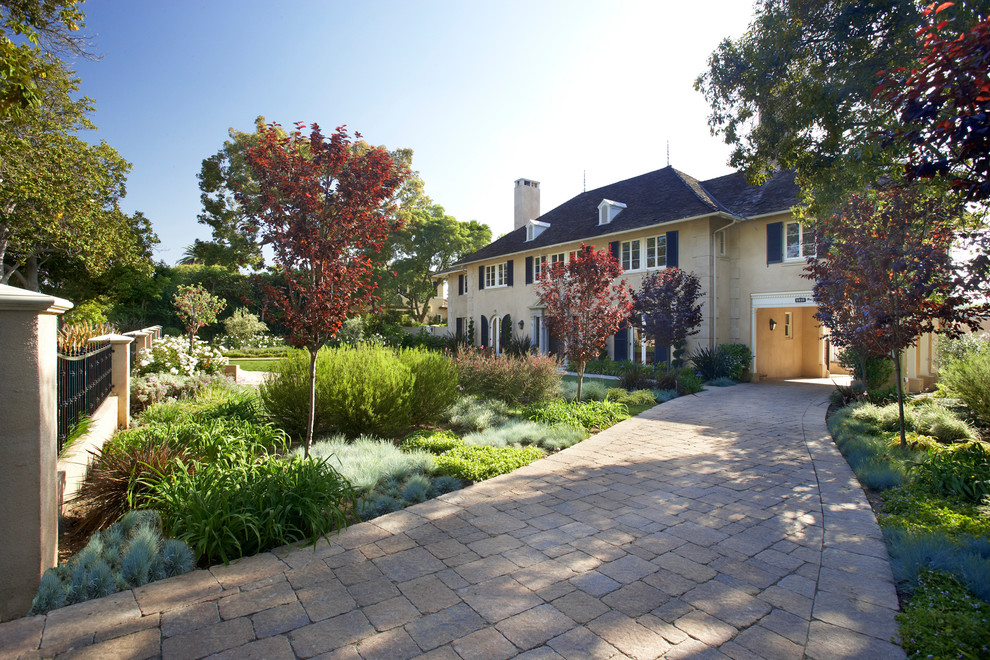 Inspiration for a mid-sized eclectic front yard partial sun driveway in Los Angeles with brick pavers.