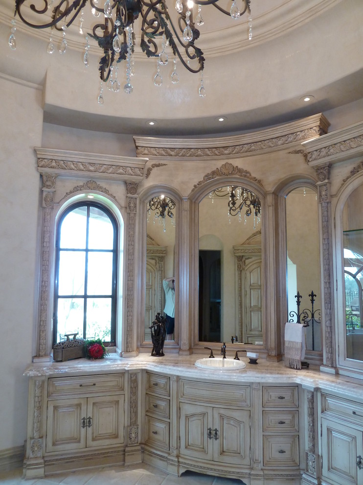 Expansive mediterranean master bathroom in Phoenix with flat-panel cabinets, light wood cabinets, a hot tub, a double shower, a one-piece toilet, beige tile, stone tile, beige walls, travertine floors, an integrated sink and tile benchtops.