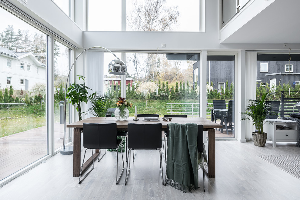 This is an example of a large contemporary open plan dining in Stockholm with light hardwood floors and grey floor.