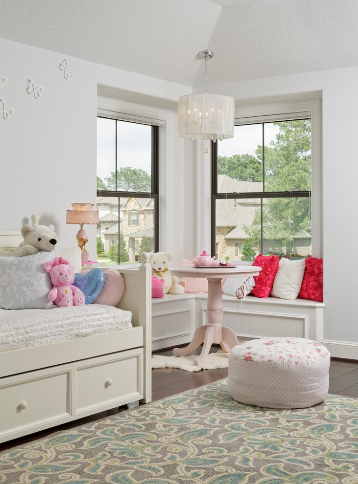 Photo of a large mediterranean kids' bedroom for girls in Houston with white walls and dark hardwood floors.