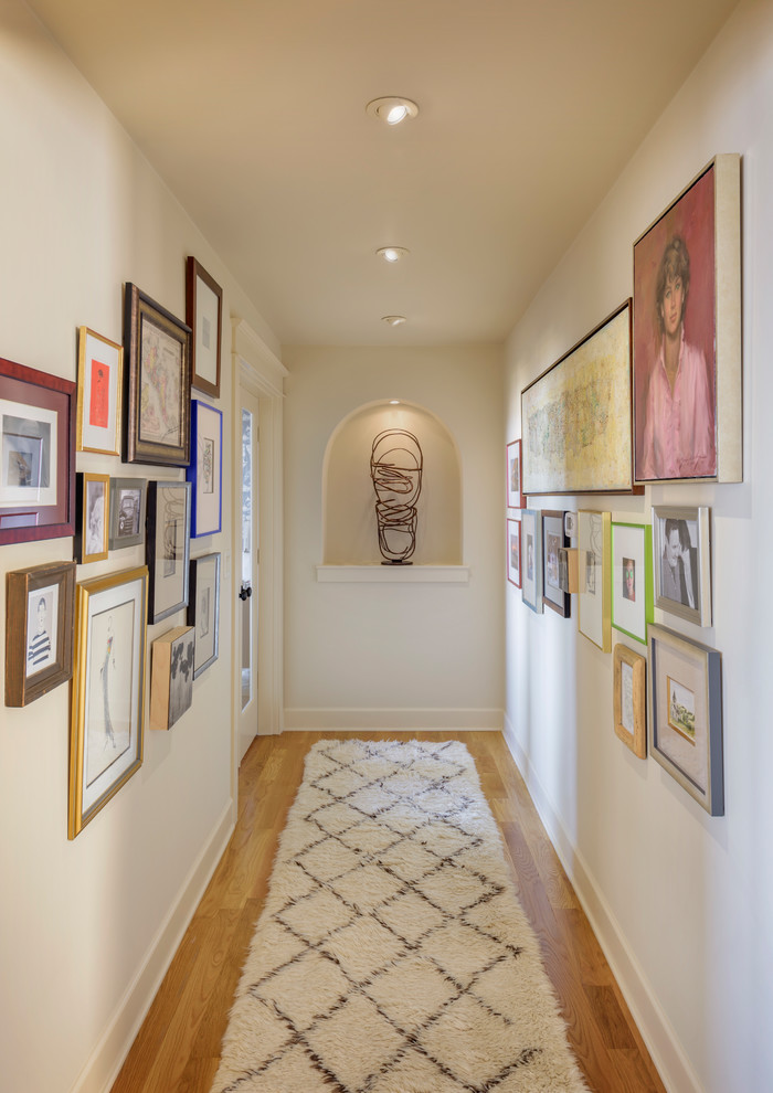Design ideas for a small transitional hallway in Portland with beige walls, light hardwood floors and brown floor.