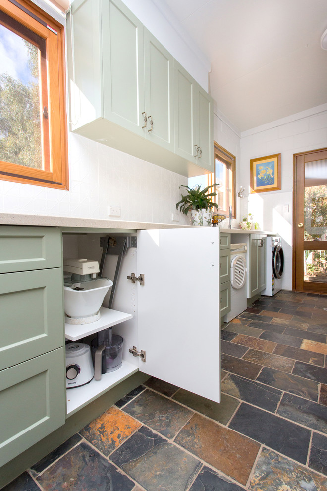 Inspiration for a small country galley kitchen in Other with a double-bowl sink, shaker cabinets, green cabinets, solid surface benchtops, white splashback, metal splashback, slate floors, multi-coloured floor and beige benchtop.