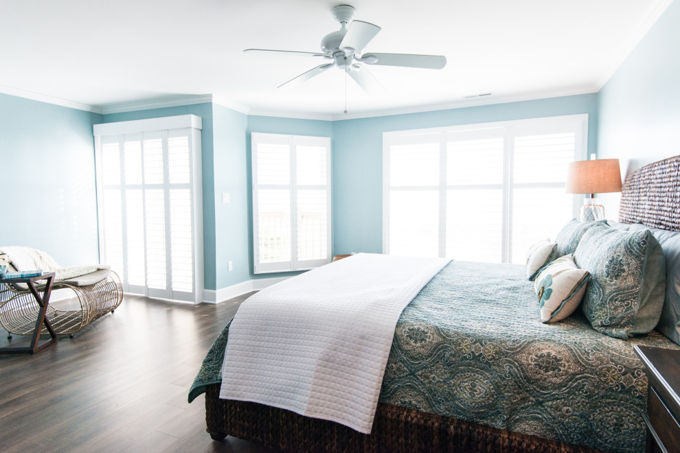 Large beach style master bedroom in Other with blue walls and vinyl floors.