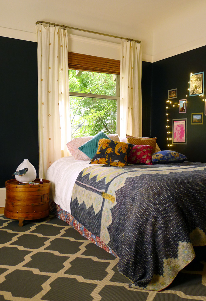 Photo of an eclectic bedroom in San Francisco with black walls and medium hardwood floors.