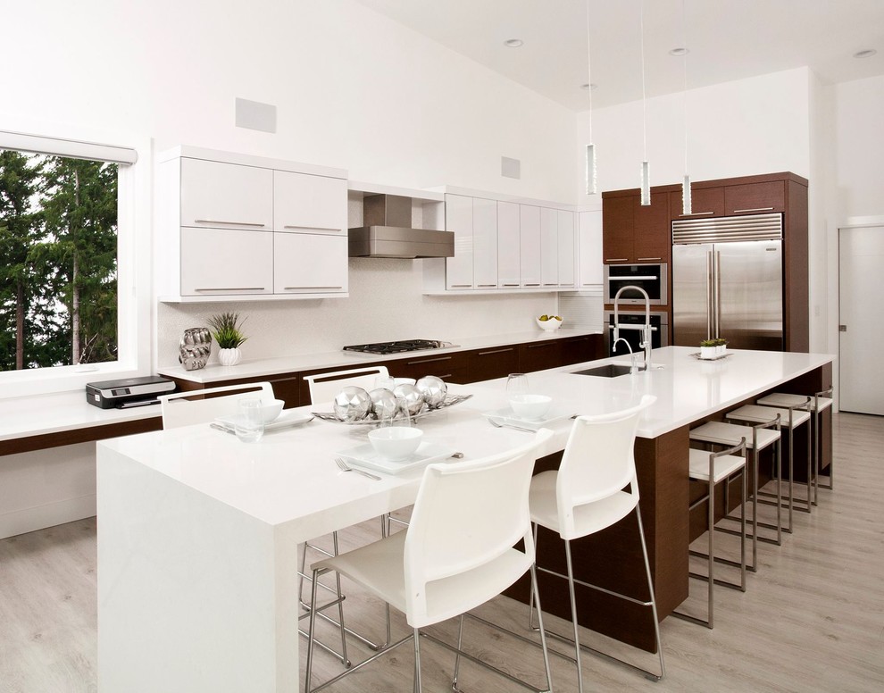 Design ideas for a large modern l-shaped eat-in kitchen in Seattle with an undermount sink, flat-panel cabinets, white cabinets, quartzite benchtops, white splashback, stone slab splashback, stainless steel appliances, light hardwood floors, with island and grey floor.