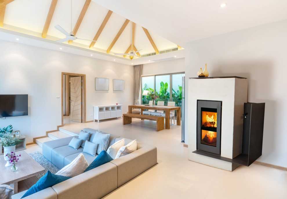 Photo of a large scandinavian enclosed family room in Essex with white walls, ceramic floors, a wood stove, a plaster fireplace surround, a wall-mounted tv, beige floor and vaulted.