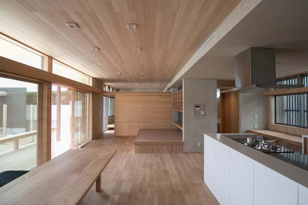 Modelo de sala de estar abierta pequeña con paredes beige, suelo de madera clara y madera