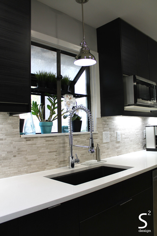 This is an example of a mid-sized modern galley eat-in kitchen in Houston with a single-bowl sink, flat-panel cabinets, black cabinets, quartz benchtops, grey splashback, stone tile splashback, stainless steel appliances and no island.
