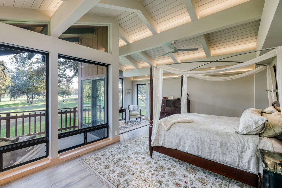 This is an example of a large contemporary master bedroom in Sacramento with porcelain floors, beige floor, white walls and exposed beam.