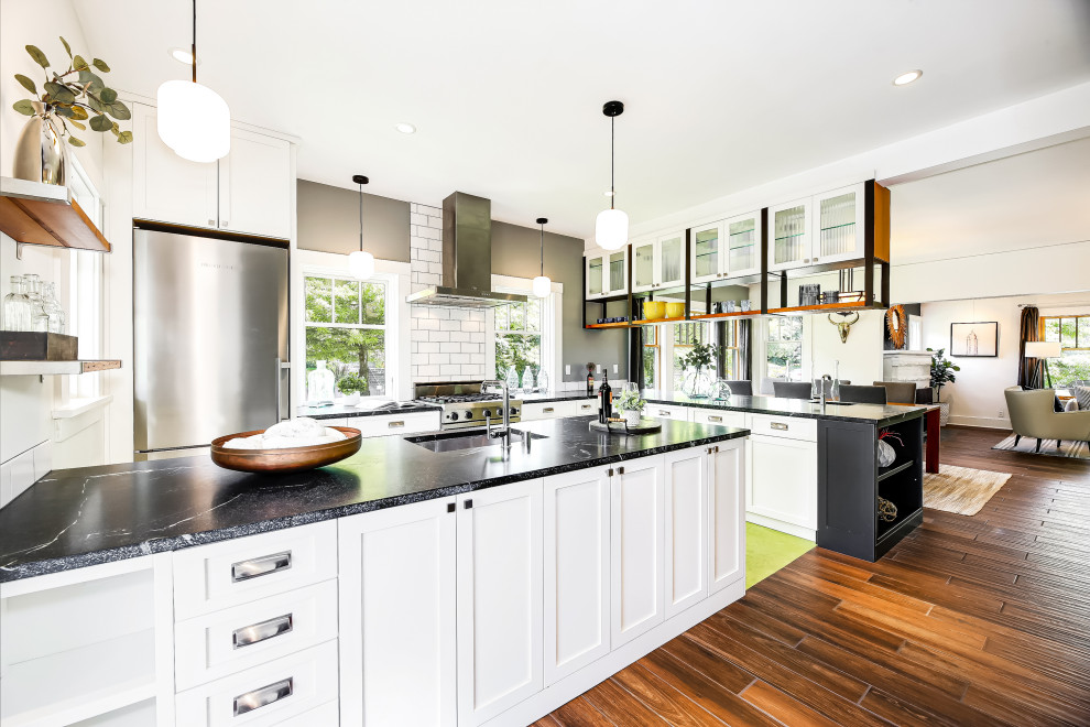 Idéer för att renovera ett mellanstort amerikanskt svart svart kök, med en undermonterad diskho, luckor med infälld panel, vita skåp, marmorbänkskiva, vitt stänkskydd, stänkskydd i porslinskakel, rostfria vitvaror, linoleumgolv, en halv köksö och grönt golv