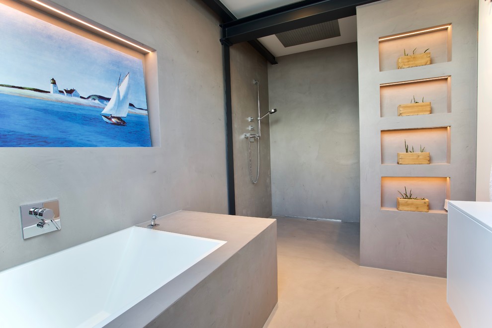 Design ideas for a large modern bathroom in Dusseldorf with flat-panel cabinets, white cabinets, a drop-in tub, a curbless shower, gray tile, cement tile, grey walls, concrete floors, an integrated sink, solid surface benchtops, grey floor, an open shower and white benchtops.