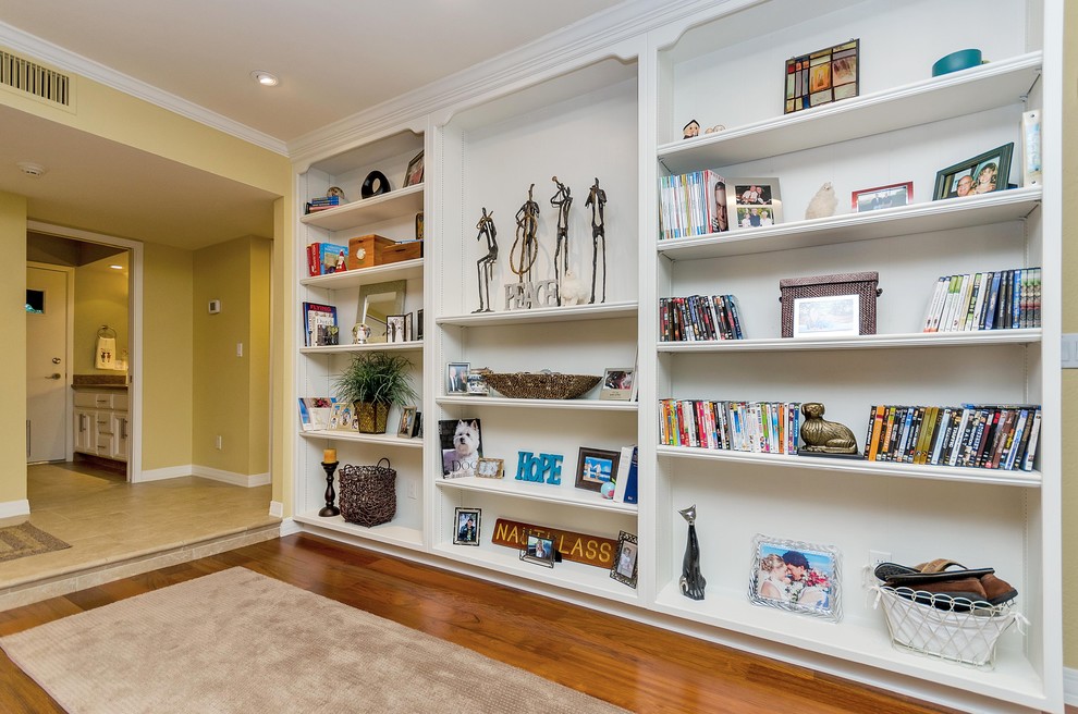 Photo of a mid-sized transitional open concept family room in Phoenix with a home bar, yellow walls, medium hardwood floors, a two-sided fireplace and a wall-mounted tv.