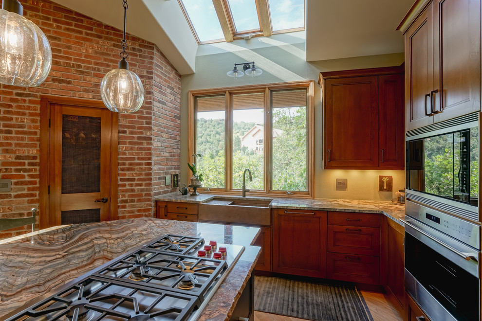 Mid-sized transitional medium tone wood floor and brown floor kitchen photo in Denver with a farmhouse sink, recessed-panel cabinets, medium tone wood cabinets, granite countertops, paneled appliances and an island