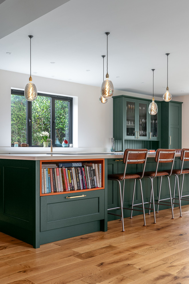 Offene, Geräumige Klassische Küche in U-Form mit Schrankfronten im Shaker-Stil, grünen Schränken, Elektrogeräten mit Frontblende, Kücheninsel und weißer Arbeitsplatte in Hampshire