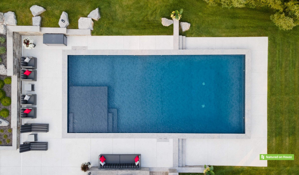 Ispirazione per una grande piscina stile rurale rettangolare dietro casa con paesaggistica bordo piscina e cemento stampato