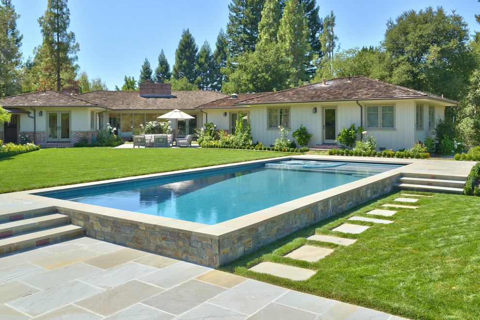 Photo of a large arts and crafts backyard rectangular lap pool in San Francisco with concrete pavers.