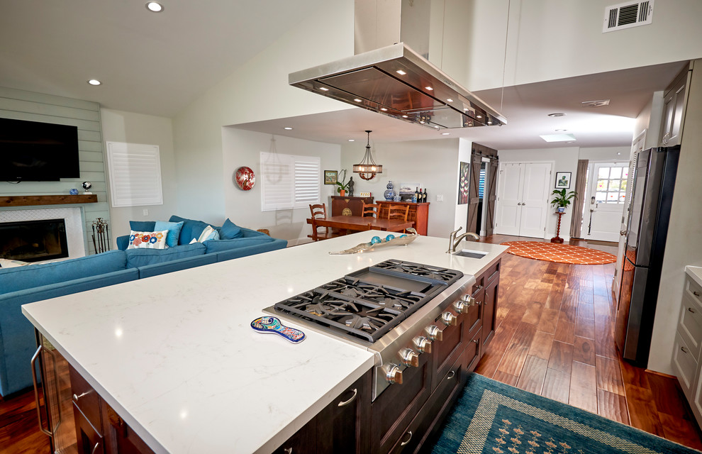 Inspiration for a large transitional l-shaped medium tone wood floor and brown floor open concept kitchen remodel in Denver with an undermount sink, recessed-panel cabinets, gray cabinets, quartz countertops, white backsplash, marble backsplash, stainless steel appliances, an island and white countertops