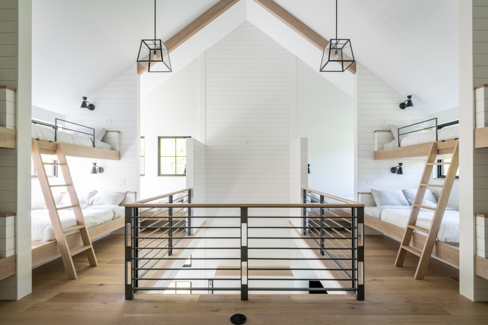 This is an example of an expansive country kids' bedroom in Other with white walls, beige floors and exposed beams.