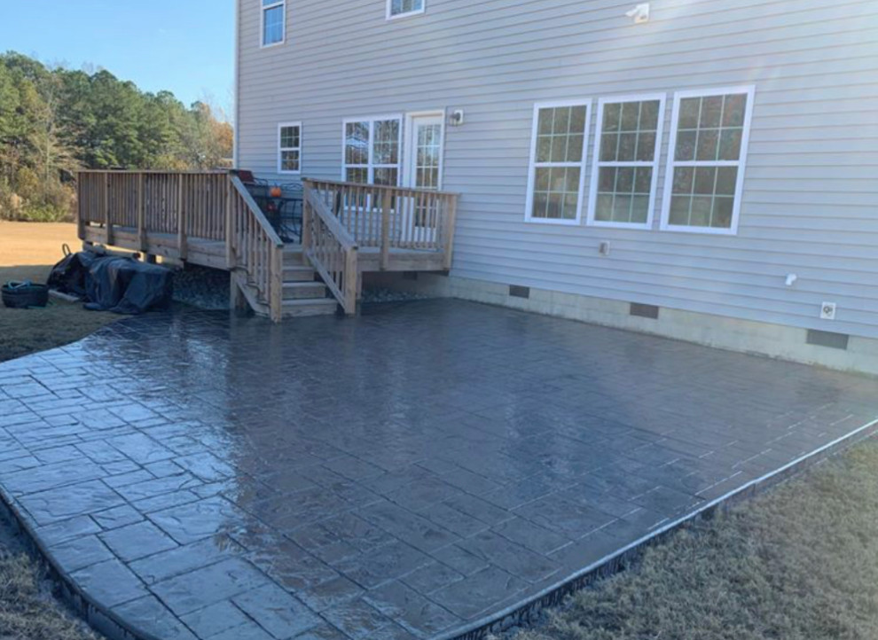Mid-sized transitional backyard stamped concrete patio photo with no cover
